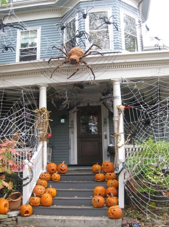 spiderwebs wtih large spiders and carved pumpkins create a stunning Halloween look for the front porch