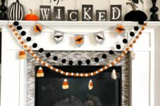 56 Halloween garlands with candy corns, kisses and black pompoms are great for styling a Halloween mantel