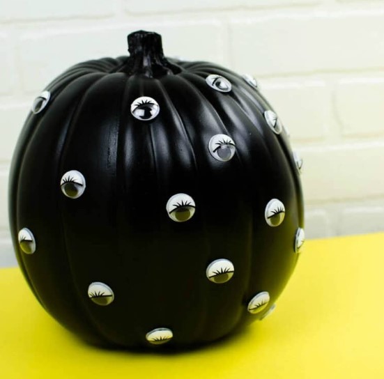 a black Halloween pumpkin with googlye eyes is a catchy decor idea that is veyr easy to realize