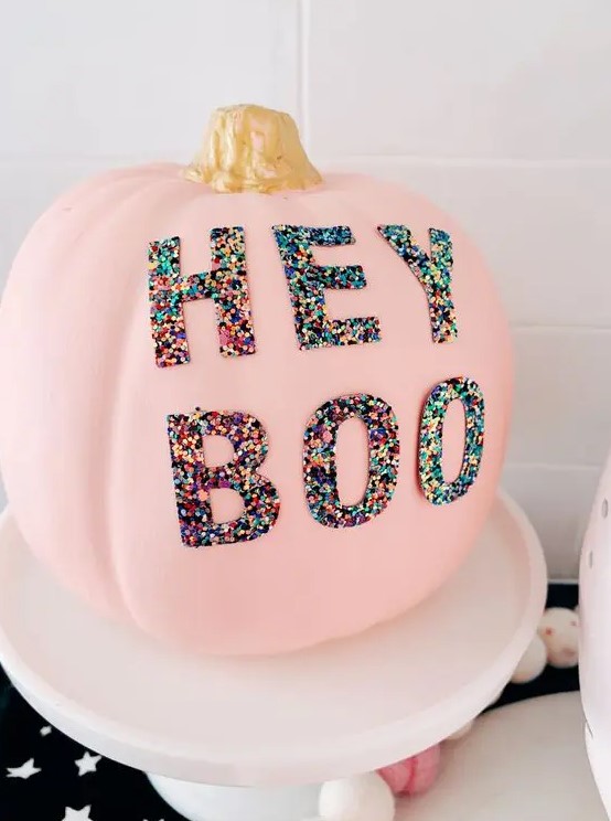 a pink Halloween pumpkin decorated with colorful sequin letters is a lovely and fun idea for the party