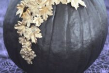 66 a shiny black pumpkin decorated with gold leaves on top is a chic and beautiful solution that feels like Halloween