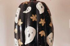 71 a beautiful painted black Halloween pumpkin with flowers and ghosts is a cool and chic solution