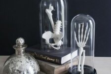 Halloween decor with books and cloches containing skeleton fragments is a lovely idea for a modern space, you can make these quickly