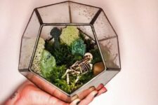 a Halloween cemetarium with moss, a skeleton and a pebble is a lovely decor idea to realize