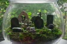 a Halloween cemetarium with moss, greenery and a graveyard is a stylish decor idea that looks natural