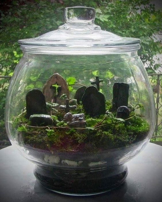 a Halloween cemetarium with moss, greenery and a graveyard is a stylish decor idea that looks natural