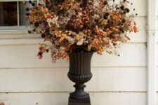 a bold outdoor floral arrangement for Halloween done with berries and dried blooms and foliage