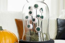 a bright Halloween cloche with moss, eyeballs on sticks is a cool and fun decoration, suitable for kids’ parties