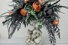 a catchy Halloween flower arrangement in orange and black, with green and black leaves, with skulls in the vase