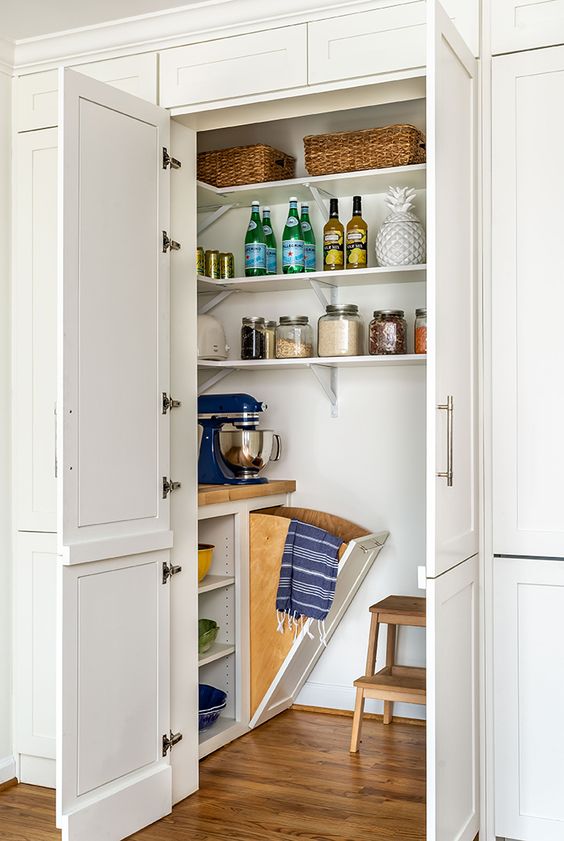 a cool small pantry with corner shelves, a built-in open storage unit, a stool and some cookware and appliances
