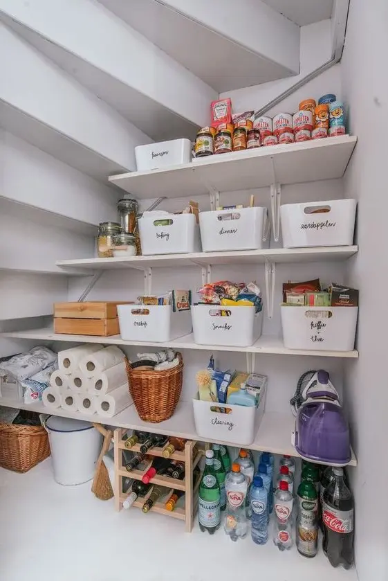 a cool under stairs pantry with open shelves, a wine bottle stand, plastic cubbies, some baskets is a lovely idea