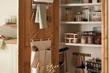 a cozy small pantry with open shelves, some baskets, food containers and storage, some things attached to the door