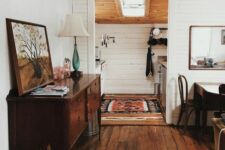 a farmhouse meets boho space with a rich-stained floor, dark-stained furniture and some boho textiles and artwork