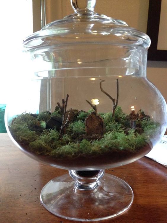 a jar with a lid, with moss, branches and tombstones is a simple and fast to realize Halloween solution