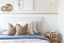 a minimal beach bedroom with a shiplap headboard, a grey bed with blue and white bedding, a wooden nightstand and a pendant lamp