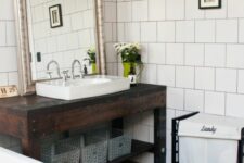 a modern boho bathroom with a dark-stained vanity and a sink, a black clawfoot tub and a printed tile floor