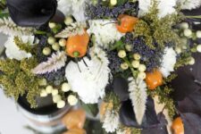 a moody Halloween flower arrangement of white blooms, berries, peppers, black callas and some greenery