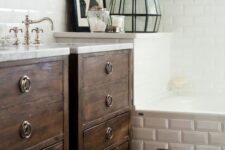 a neutral bathroom with dark-stained vanities, a bathtub clad with tiles, vintage fixtures and a dark-stained stool