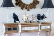 a refined entryway console with black lamps, blackbirds, black candleholders, a black house and Halloween trees