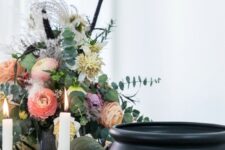 a refined floral Halloween centerpiece with peachy and pink blooms, dried blooms and grasses and much eucalyptus