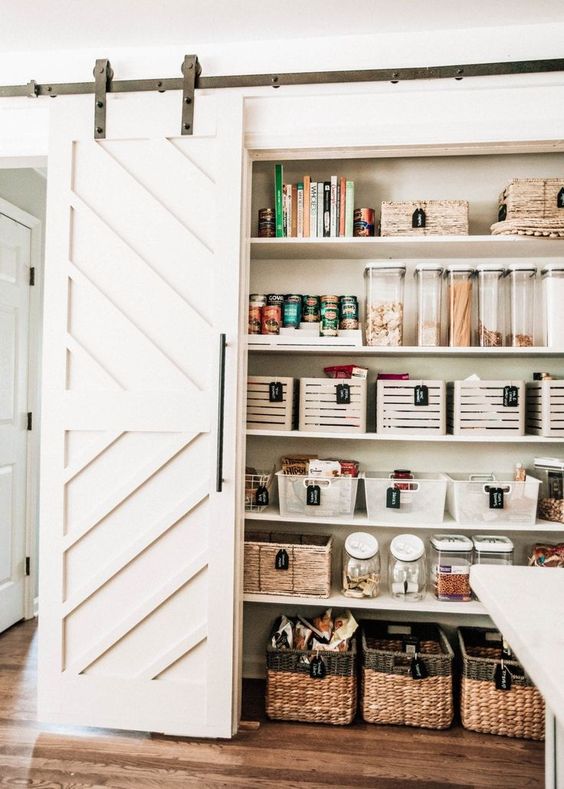 a rustic pantry with barn doors, baskets, cubbies and containers and jars is a cool idea for a rustic kitchen