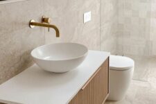 a serene neutral bathroom with neutral Zellige and stone tiles, a floating reeded vanity with a bowl sink, a mirror and a shower space