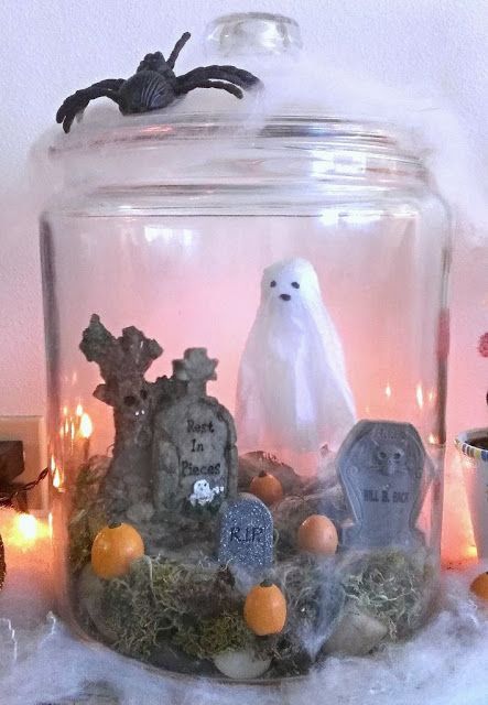 a simple Halloween terrarium with moss, mini pumpkins, tombstones, a ghost is very easy to repeat