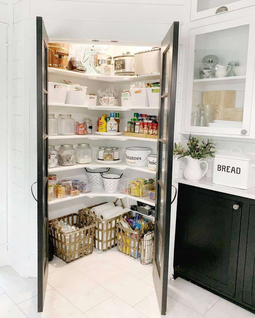 A small corner pantry with corner shelves, baskets and lights plus glass doors to make it more light filled is cool and chic