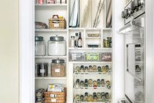 a small pantry with a large open shelving unit, metal shelves and jars and baskets, some food and other stuff