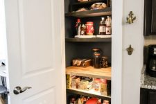 a small pantry with open shelves and built-in lights, metal wire baskets and various food and drinks is a lovely solution