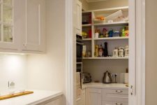 a small pantry with open shelves and built-in storage cabnets, appliances, food and cookware to keep the kitchen clean and decluttered