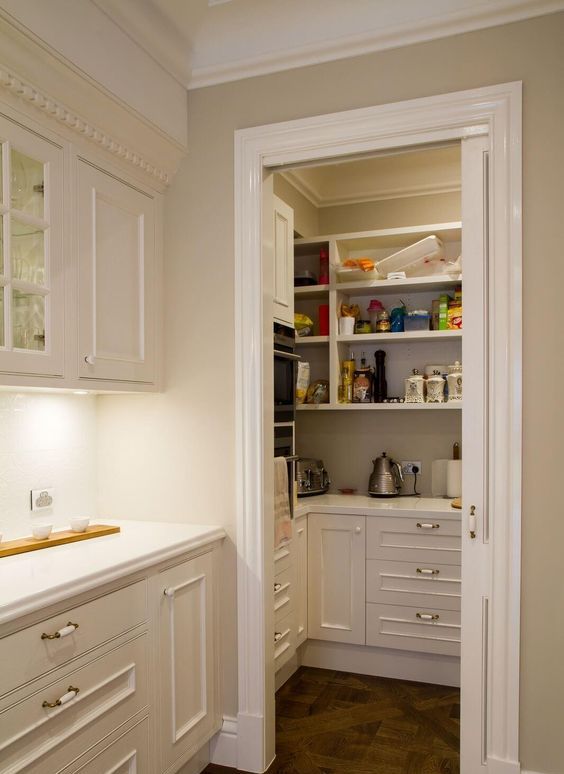 A small pantry with open shelves and built in storage cabnets, appliances, food and cookware to keep the kitchen clean and decluttered
