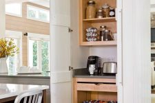 a small pantry with open shelves and drawers, with cookware and appliances is a cool idea for any kitchen