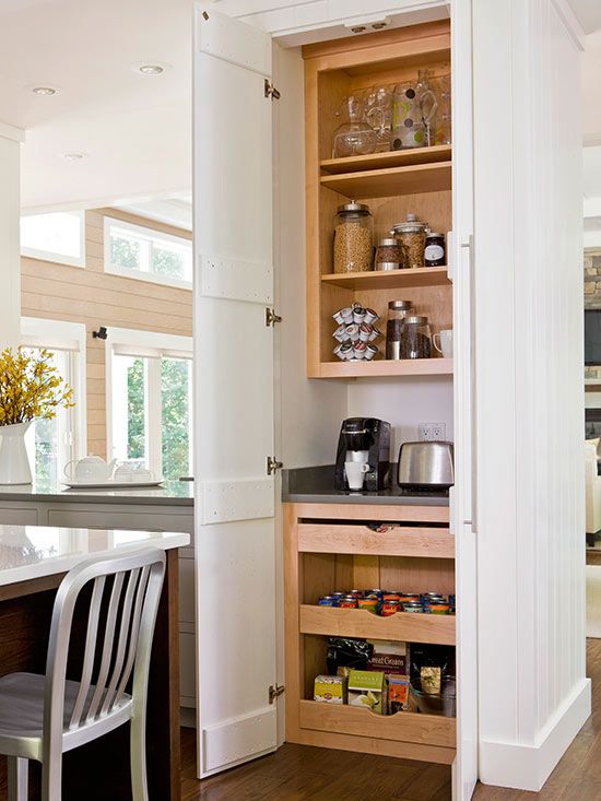 a small pantry with open shelves and drawers, with cookware and appliances is a cool idea for any kitchen