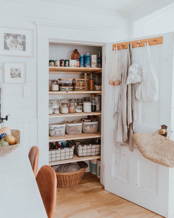 a small pantry with open shelves, cubbies, containers and a basket is a great space for storage