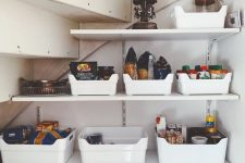 a small yet well-organized under stairs pantry with open shelves and plastic cubbies is a cool solution to save your space