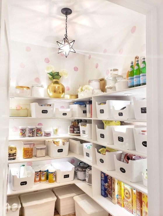 A smart and cool staircase pantry with open shelves, plastic cubbies, lights, printed wallpaper and a star shaped pendant lamp