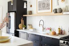 a soot kitchen with an open shelf instead of upper cabinets, a kitchen island with a white stone counter and some gold touches