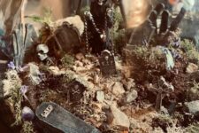 a spooky Halloween terrarium with moss, pebbles, skulls, Death, some rocks and tombstones is cool
