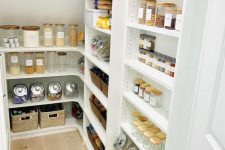 a staircase hiding a pantry with open shelves and cubbies is a cool way to save a lot of floor space easily