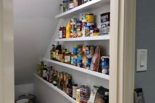 a staircase pantry with open shelves, boxes and additional lights is a smart and easy solution to store food