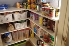 a tiny and well-organized pantry with a built-in shelving unit, plastic crates, additional light is a super smart idea