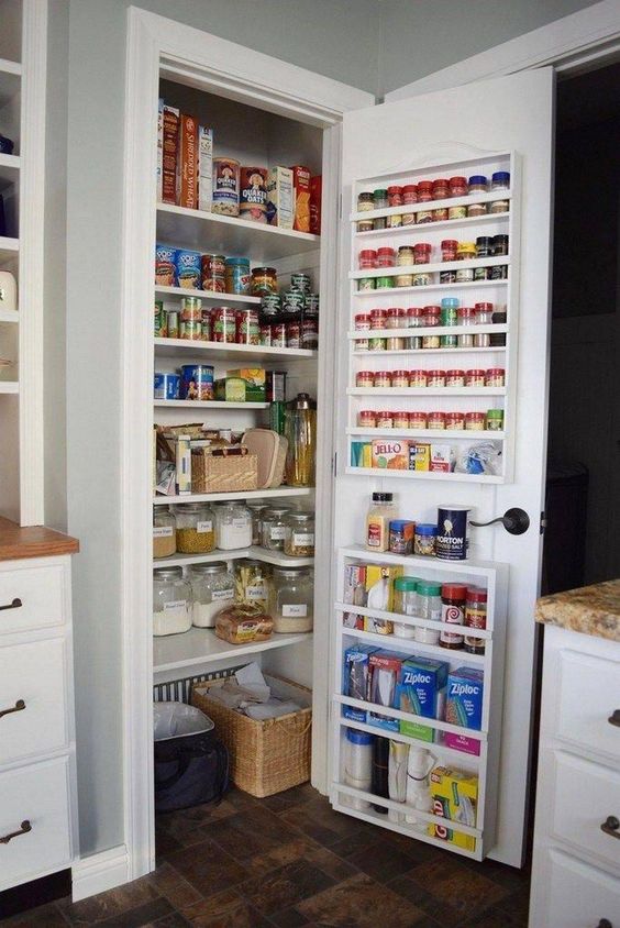 A tiny built in pantry with open shelves, baskets and cubbies, shelves attached to the door is a cool solution