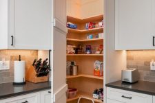 a tiny hidden pantry with lights, open shelving and a small stool is a smart solution for any kitchen