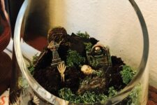a very easy to make and fast Halloween terrarium with moss, skulls, bones and tombstones is a cool idea