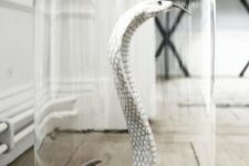 a white snake in a cloche is an elegant and scary Halloween decoration you can make
