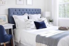 an eye-catching bedroom with a blue bed, blue and white bedding, a printed rug, a white desk and a navy chair