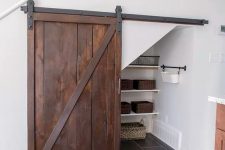 an under the stairs pantry with shelves, cubbies and baskets and a barn door for a more rustic feel