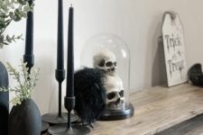 modern Halloween decorating with black candles, a cloche with skulls, greenery and some decor is a fast to realize idea