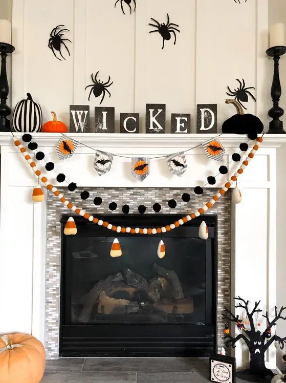 Halloween garlands with candy corns, kisses and black pompoms are great for styling a Halloween mantel